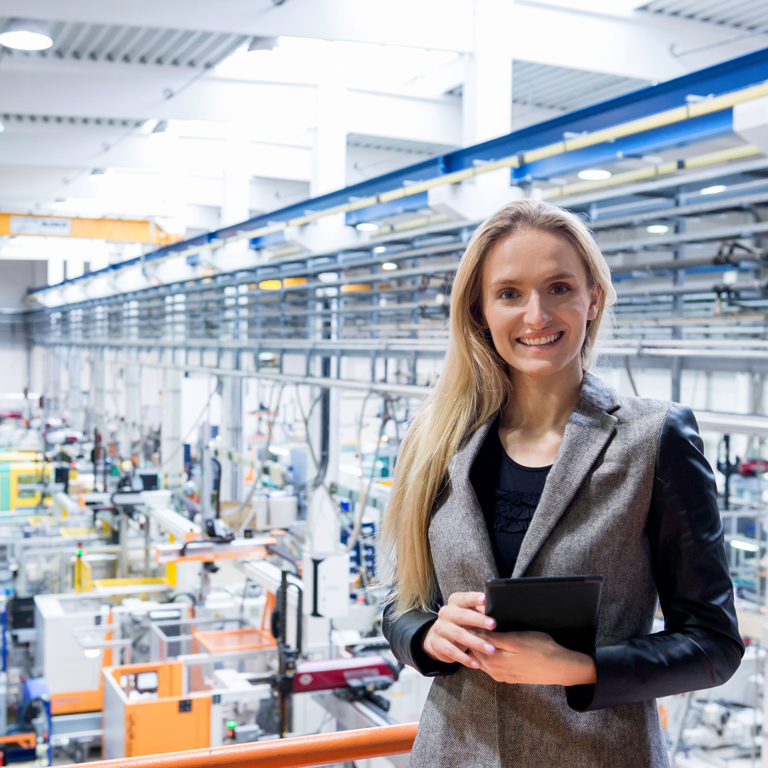 business woman holding tablet in factory